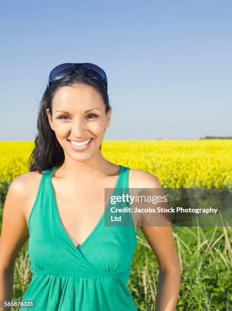 indian woman smiling in field of flowers - spalding place stock-fotos und bilder