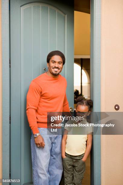 african american father and daughter smiling in doorway - answering door stock pictures, royalty-free photos & images