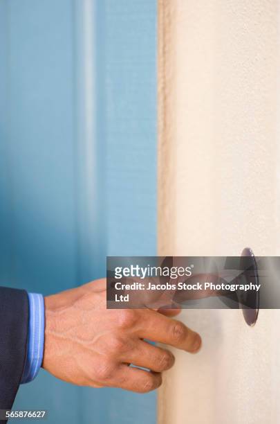 hispanic businessman ringing doorbell - türklingel stock-fotos und bilder