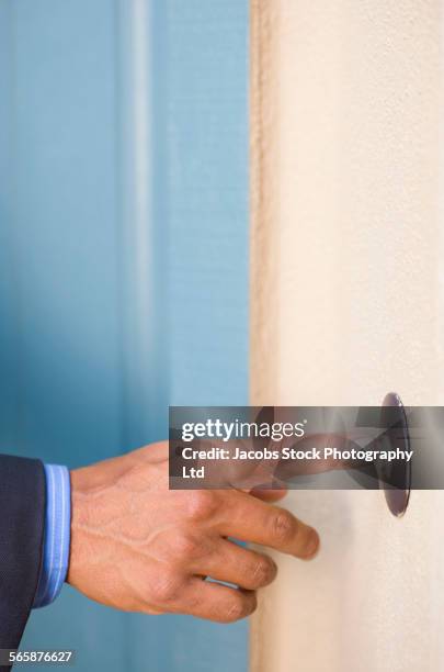 hispanic businessman ringing doorbell - timbre de la puerta fotografías e imágenes de stock