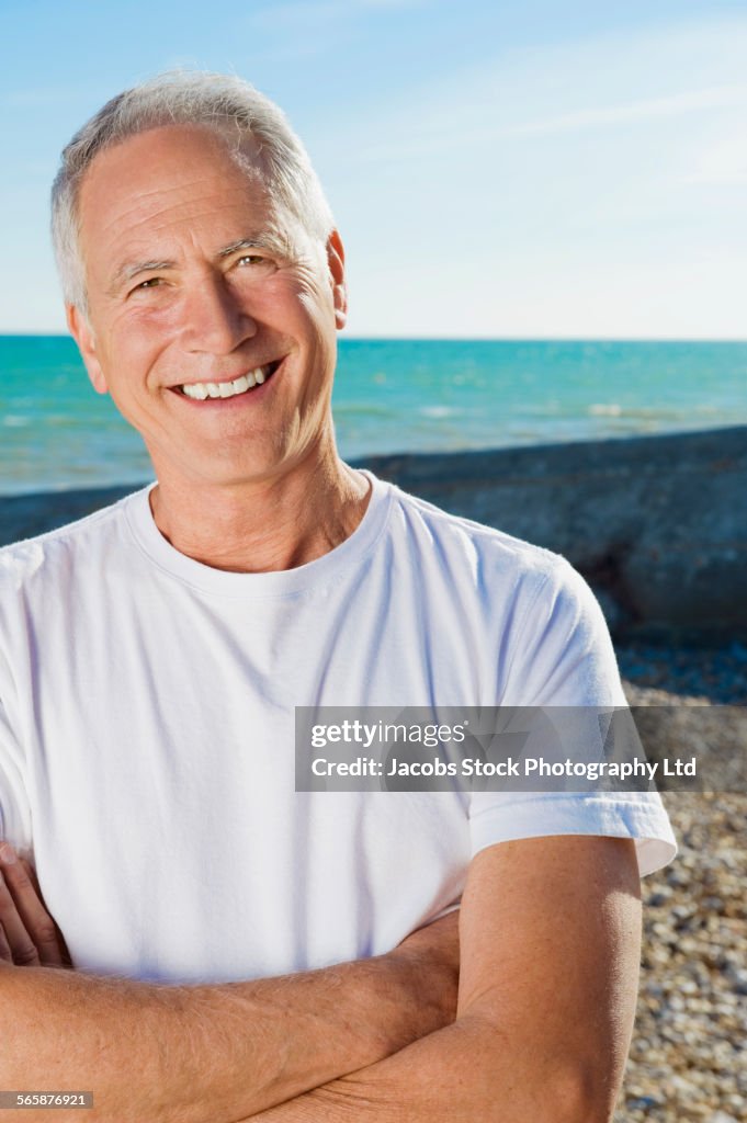 Smiling Caucasian man standing on beach