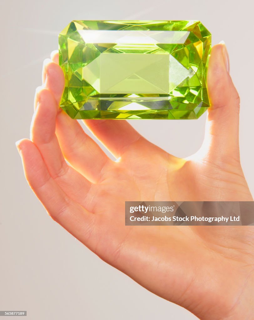 Caucasian woman holding oversized jewel