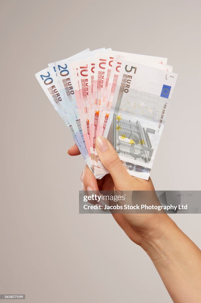 Caucasian woman holding Euro notes