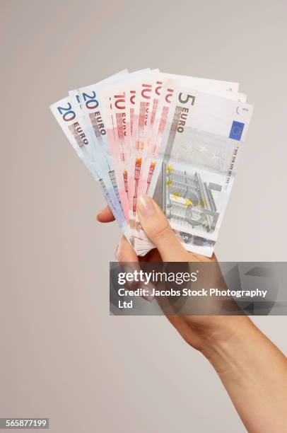 caucasian woman holding euro notes - euro in hand stock pictures, royalty-free photos & images