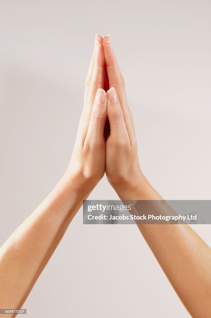 Close up of clasped hands of Caucasian woman