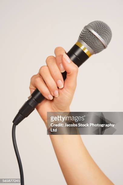 caucasian woman holding microphone - microfoon fotografías e imágenes de stock