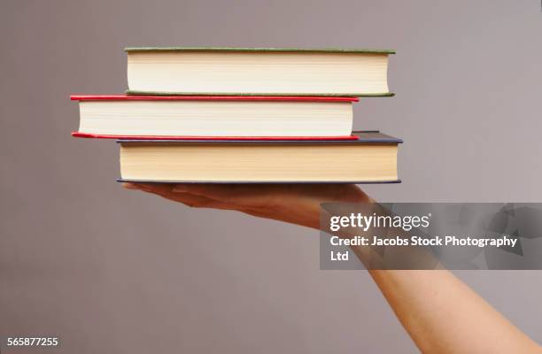 caucasian woman holding stack of books - book hand stock pictures, royalty-free photos & images