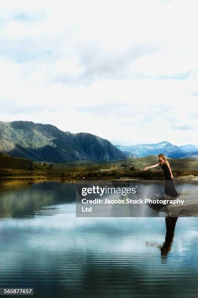 pacific islander woman wearing evening gown near remote lake - skip stockfoto's en -beelden