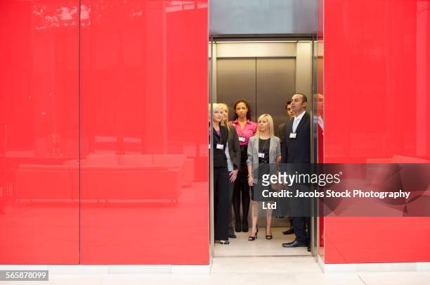 business people standing in office elevator - lift stock-fotos und bilder