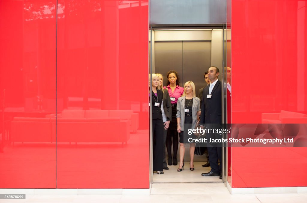 Business people standing in office elevator