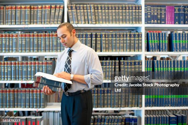 indian businessman reading book in law library - law book stock pictures, royalty-free photos & images