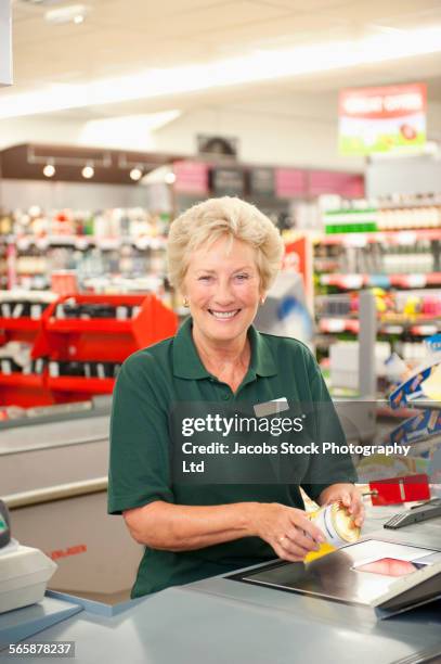 caucasian cashier working at grocery store checkout - blonde english woman shopping foto e immagini stock