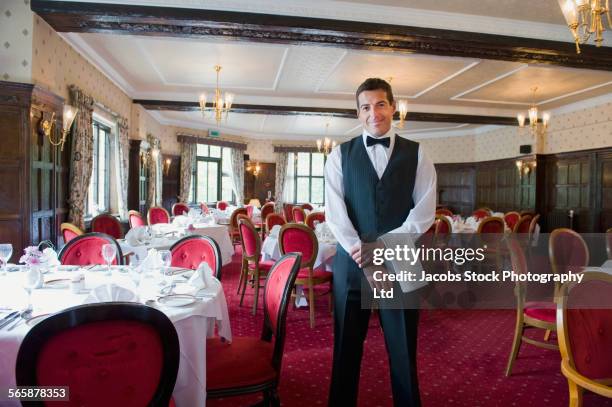 caucasian waiter smiling in empty restaurant - camarero fotografías e imágenes de stock