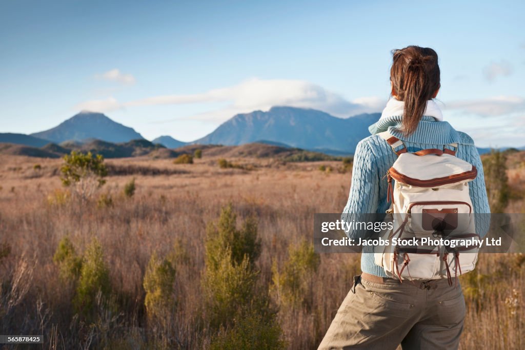 Hispanic hiker standing in remote field