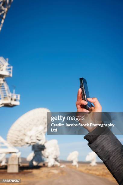 hispanic woman taking cell phone photograph of satellite - signal stock-fotos und bilder