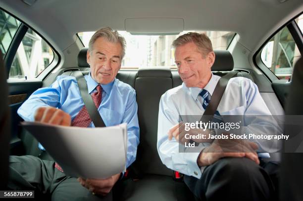 caucasian businessmen working in back seat of car - conversation car bildbanksfoton och bilder