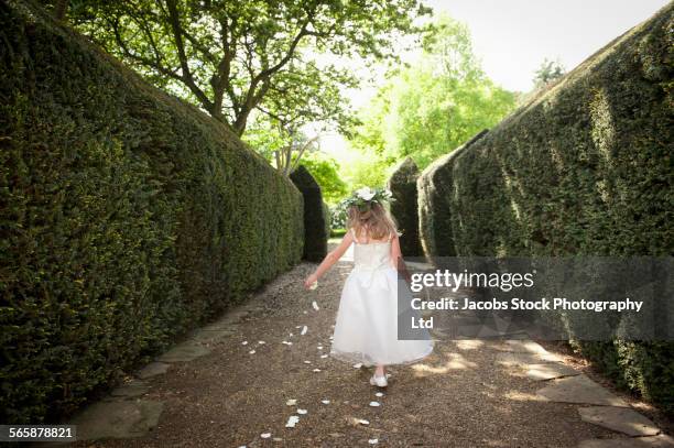 caucasian flower girl sprinkling petals in garden - flower girl stock pictures, royalty-free photos & images