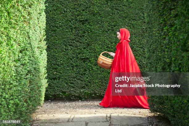 caucasian woman wearing red cape in garden - cape verde imagens e fotografias de stock