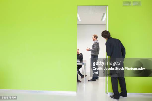 caucasian businessman peeking in at office meeting - peeking ストックフォトと画像