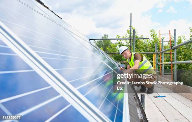 caucasian technician working on solar panels - eco house stockfoto's en -beelden