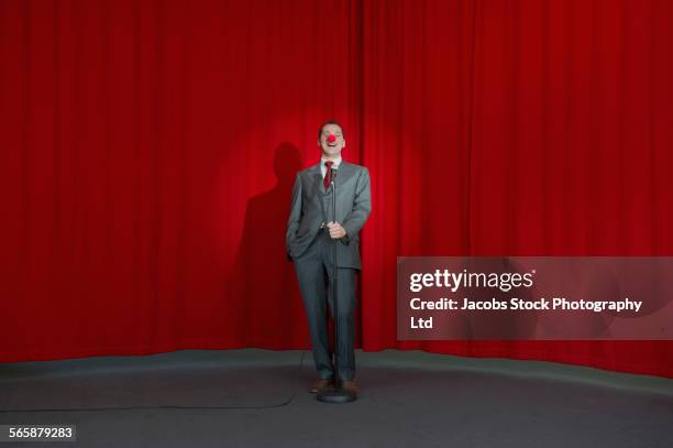 caucasian businessman performing comedy on stage - komiek stockfoto's en -beelden