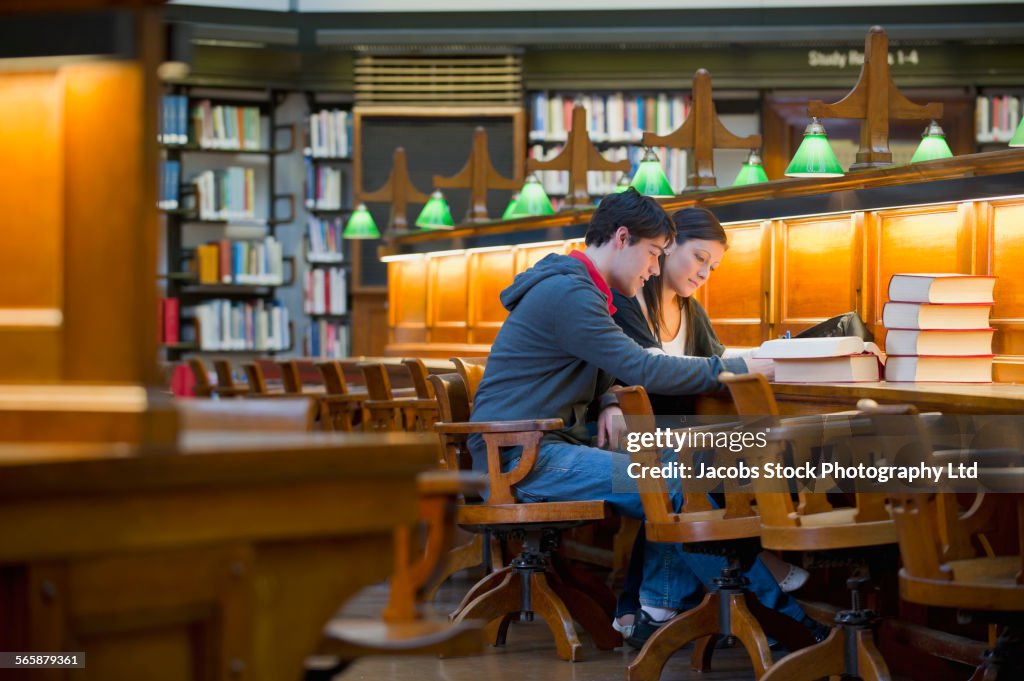 Caucasian students studying together in library