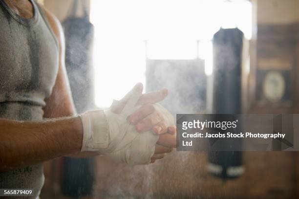 caucasian boxer chalking hands in gymnasium - boksen sport stockfoto's en -beelden