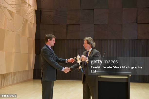 caucasian businessman receiving trophy and handshake - receiving award stock pictures, royalty-free photos & images