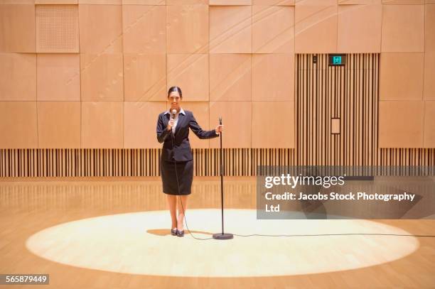 caucasian businesswoman talking into microphone in spotlight - overheidsberoep stockfoto's en -beelden