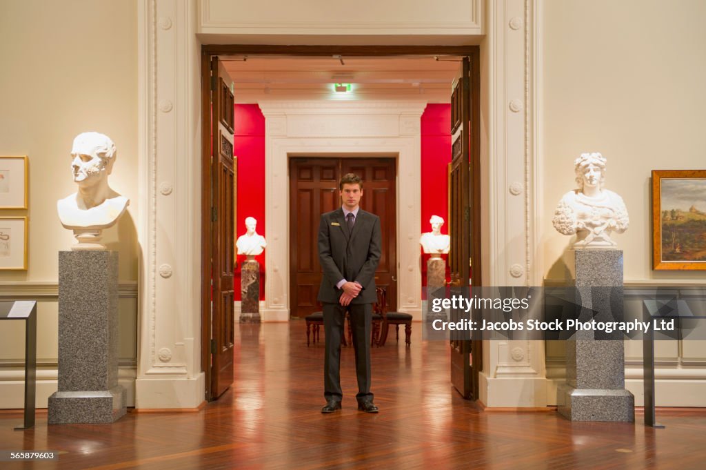 Caucasian security guard standing in art museum