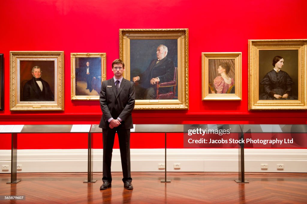 Caucasian security guard standing in art museum