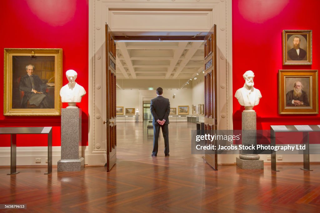Caucasian security guard standing in art museum