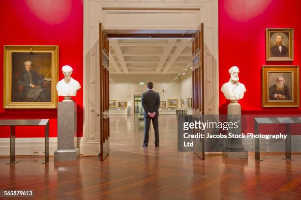 caucasian security guard standing in art museum - museum sculpture stock pictures, royalty-free photos & images