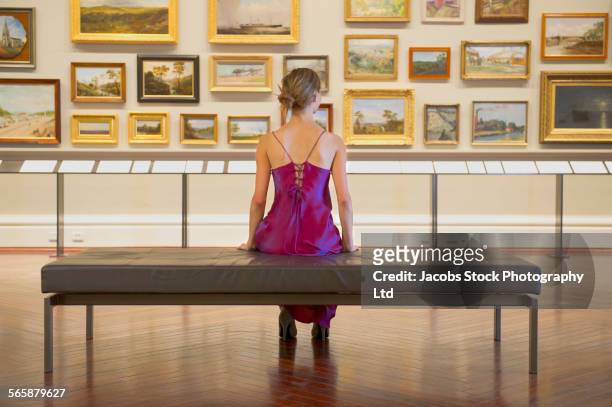 caucasian woman in evening gown admiring art in museum - vestito da sera femminile foto e immagini stock