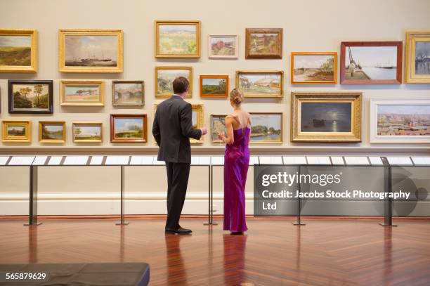 caucasian couple in evening wear admiring art in museum - abendgarderobe stock-fotos und bilder