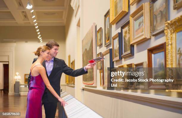 caucasian couple in evening wear admiring art in museum - couple art gallery stock pictures, royalty-free photos & images