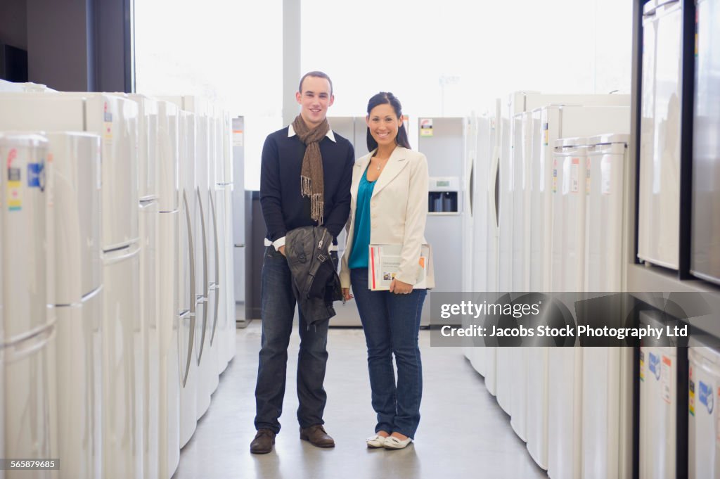 Couple smiling in kitchen appliance store