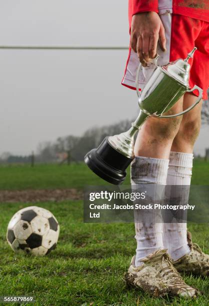 dirty caucasian boy holding trophy on soccer field - life after stroke awards 2011 stock pictures, royalty-free photos & images