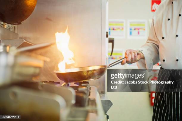 caucasian chef cooking in restaurant kitchen - chef tossing fire stock-fotos und bilder