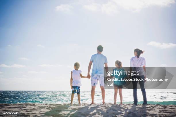 caucasian parents and children holding hands on beach - family rear view stock pictures, royalty-free photos & images