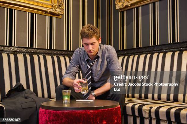 lonely caucasian businessman drinking in lounge - cocktails bar lounge stockfoto's en -beelden