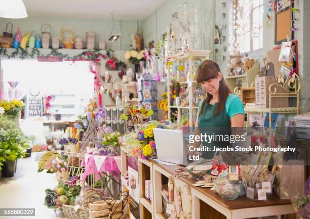 caucasian employee working on laptop in gift shop - gift shop 個照片及圖片檔