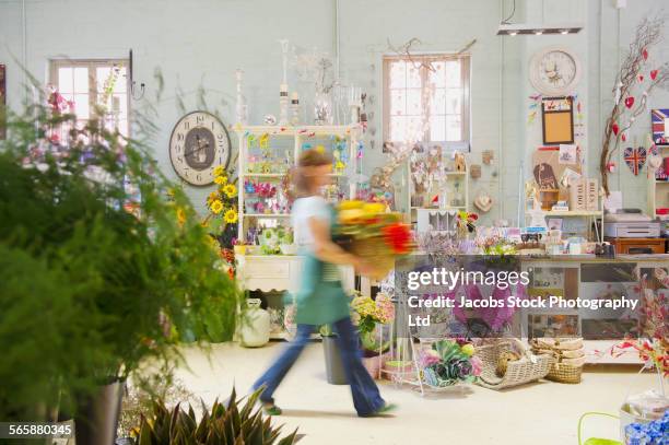 blurred view of caucasian florist working in flower shop - spalding england stock-fotos und bilder