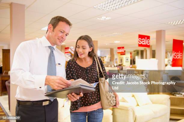 caucasian salesman talking to customer in furniture store - salesman foto e immagini stock