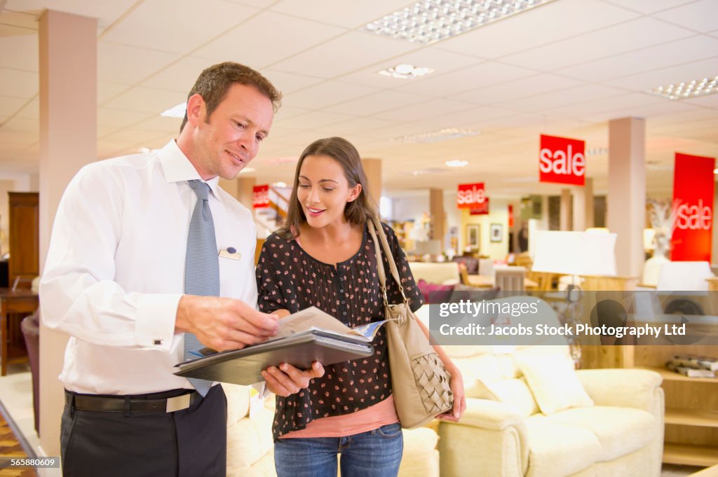 Caucasian salesman talking to customer in furniture store
