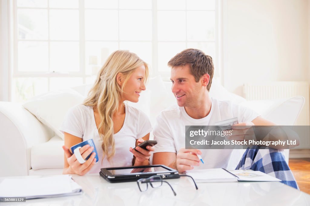 Caucasian couple in pajamas shopping online with digital tablet