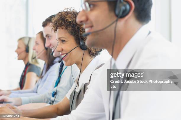 business people talking on headsets in office - international day four stock pictures, royalty-free photos & images