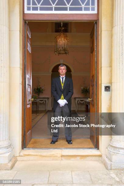 caucasian butler standing at mansion front door - victor butler stock pictures, royalty-free photos & images
