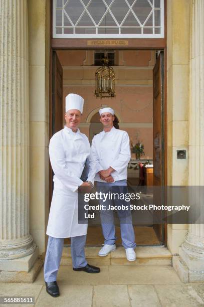 caucasian chefs standing in mansion front door - uniforme de chef fotografías e imágenes de stock