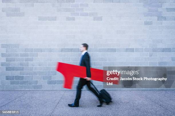 blurred view of caucasian businessman carrying number one near brick wall - one number stock-fotos und bilder